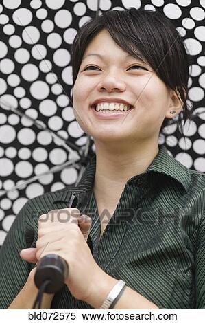 Stock Photography - Asian woman carrying umbrella. Fotosearch