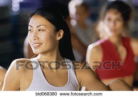 Stock Image - Asian woman in exercise class. Fotosearch