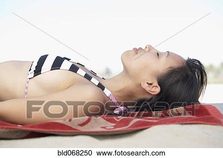 Asian woman laying on blanket at beach View Large Photo Image Stock Image - Asian woman laying on blanket at beach. Fotosearch