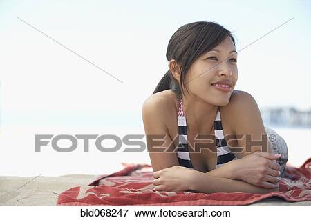 Asian woman laying on blanket at beach View Large Photo Image Stock Photo - Asian woman laying on blanket at beach. Fotosearch