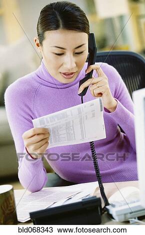 Asian woman on telephone with bill View Large Photo Image Stock Image - Asian woman on telephone with bill. Fotosearch