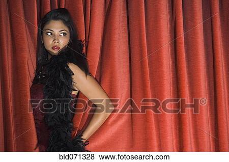 Stock Photo - Asian woman standing in curtains. Fotosearch