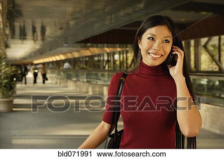 Stock Image - Asian woman talking on cell phone. Fotosearch