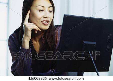 Stock Photography - Asian woman using computer. Fotosearch
