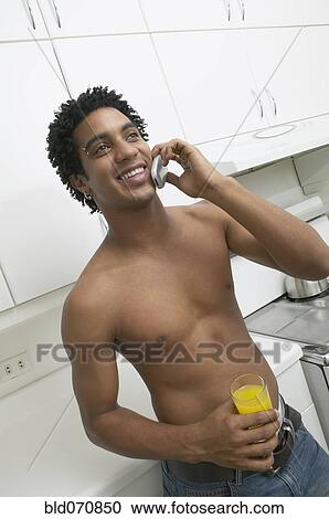 Bare-chested African man talking on cell phone View Large Photo Image Stock Image - Bare-chested African man talking on cell phone. Fotosearch