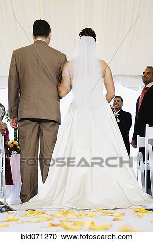 Stock Image - Bride being walked down aisle. Fotosearch
