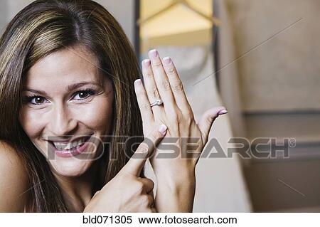 Stock Photography - Bride pointing to ring. Fotosearch