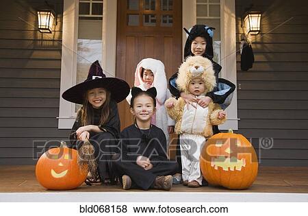 Stock Photo - Children in Halloween costumes with pumpkins. Fotosearch