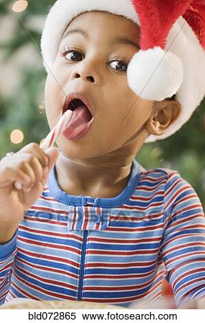 Close up of African American boy licking candy cane View Large Photo Image Stock Photography - Close up of African American boy licking candy cane. Fotosearch