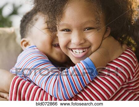 Stock Photograph - Close up of African American brother and sister hugging. Fotosearch