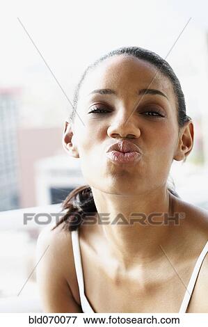 Stock Photo - Close up of African woman blowing a kiss. Fotosearch