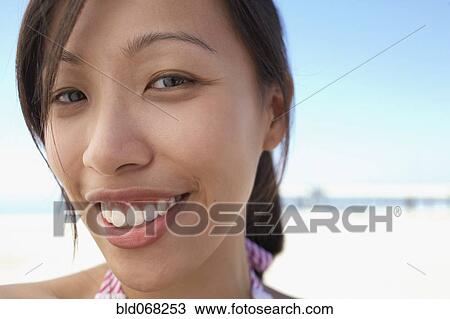 Close up of Asian woman smiling at beach View Large Photo Image Stock Image - Close up of Asian woman smiling at beach. Fotosearch