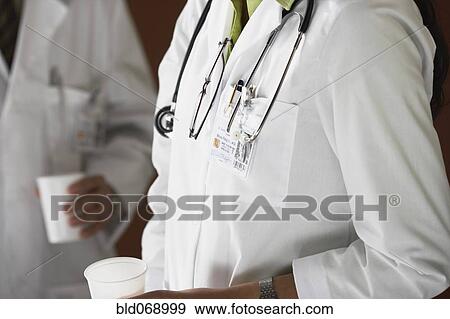 Close up of female doctor holding plastic cup View Large Photo Image Stock Photo - Close up of female doctor holding plastic cup. Fotosearch