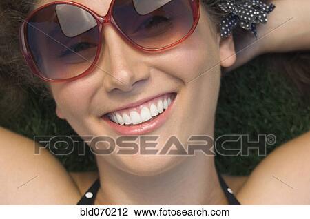 Stock Image - Close up of Hispanic woman wearing sunglasses. Fotosearch