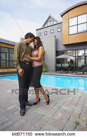 Couple hugging in front of house View Large Photo Image Stock Image - Couple hugging in front of house. Fotosearch