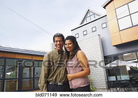 Stock Photo - Couple hugging in front of house. Fotosearch