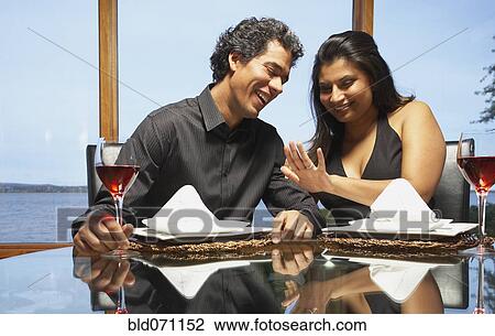 Stock Image - Couple smiling at engagement ring. Fotosearch