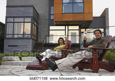 Stock Photo - Couple toasting in deck chairs. Fotosearch