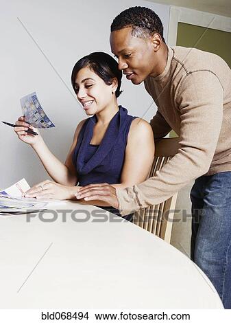 Couple viewing coupons together View Large Photo Image Picture - Couple viewing coupons together. Fotosearch