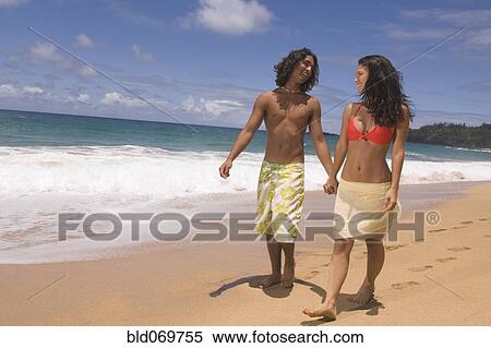 Stock Photography - Couple walking on beach. Fotosearch