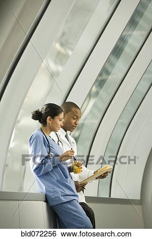 Stock Photograph - Doctor and nurse reviewing medical chart. Fotosearch