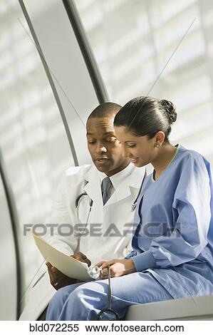 Doctor and nurse reviewing medical chart View Large Photo Image Stock Photography - Doctor and nurse reviewing medical chart. Fotosearch