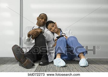 Stock Image - Doctors leaning on one another. Fotosearch