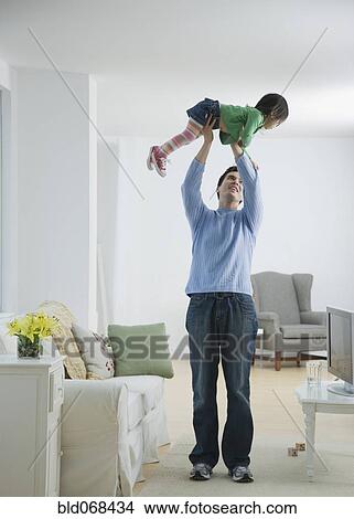 Picture - Father holding daughter above head. Fotosearch