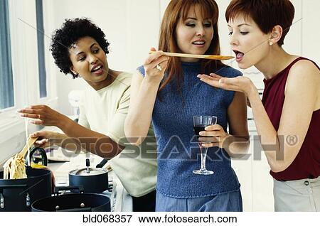 Stock Photo - Friends cooking in kitchen. Fotosearch