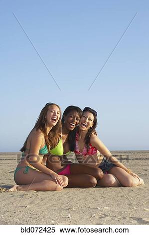 Stock Photography - Friends in bikinis at beach. Fotosearch