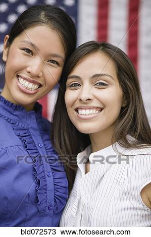Stock Image - Friends standing near American flag. Fotosearch