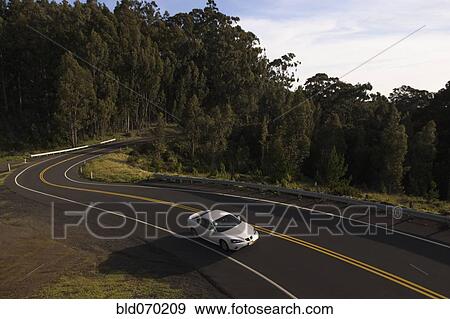 Stock Photo - High angle view of car driving on winding road. Fotosearch