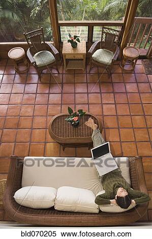 High angle view of woman using laptop on sofa View Large Photo Image Stock Photography - High angle view of woman using laptop on sofa. Fotosearch