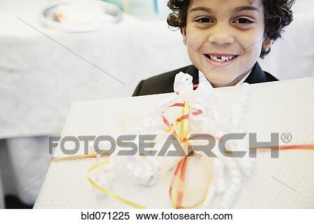 Stock Photography - Hispanic boy holding gift. Fotosearch