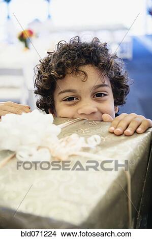 Hispanic boy looking over gift View Large Photo Image Picture - Hispanic boy looking over gift. Fotosearch