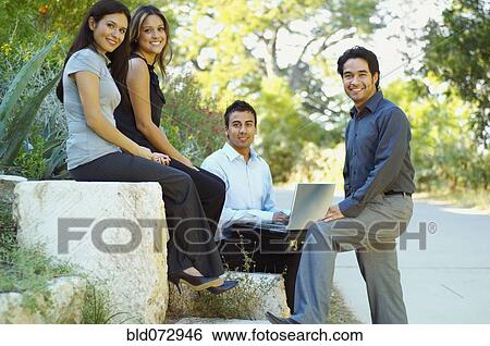 Hispanic business people using laptop outdoors View Large Photo Image Stock Photograph - Hispanic business people using laptop outdoors. Fotosearch