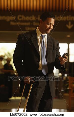 Hispanic businessman looking at cell phone View Large Photo Image Stock Image - Hispanic businessman looking at cell phone. Fotosearch