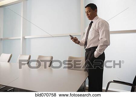 Hispanic businessman looking at electronic organizer View Large Photo Image Stock Photo - Hispanic businessman looking at electronic organizer. Fotosearch