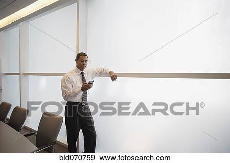 Hispanic businessman looking at electronic organizer View Large Photo Image Stock Photo - Hispanic businessman looking at electronic organizer. Fotosearch