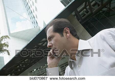 Stock Photo - Hispanic businessman talking on cell phone. Fotosearch