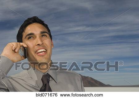 Stock Photograph - Hispanic businessman talking on cell phone. Fotosearch