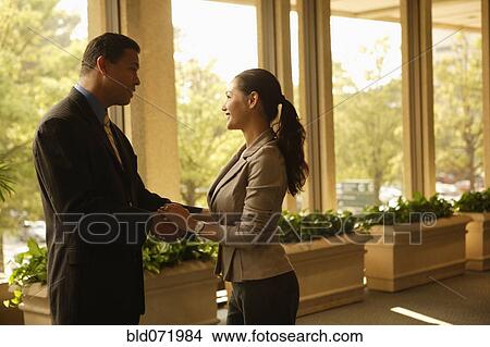 Picture - Hispanic businesspeople greeting each other. Fotosearch