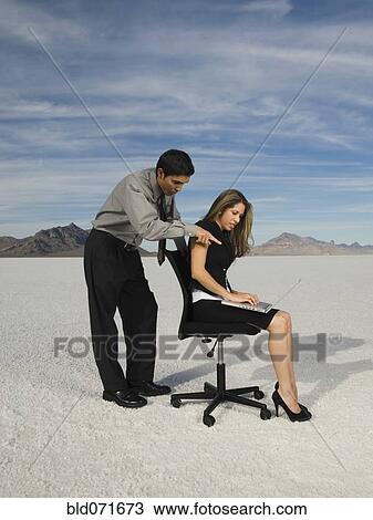 Stock Image - Hispanic businesspeople looking at laptop. Fotosearch