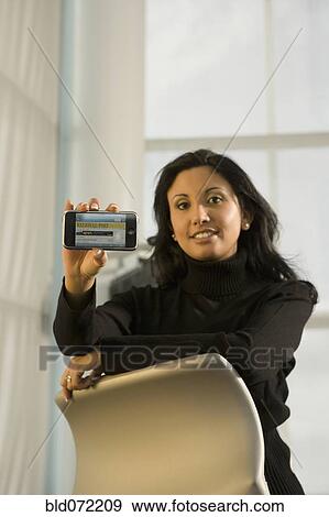 Hispanic businesswoman holding cell phone View Large Photo Image Stock Photo - Hispanic businesswoman holding cell phone. Fotosearch