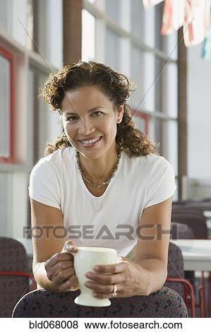Stock Photo - Hispanic businesswoman holding coffee cup. Fotosearch