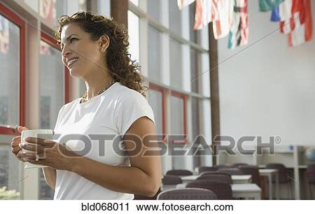 Stock Image - Hispanic businesswoman looking out window. Fotosearch
