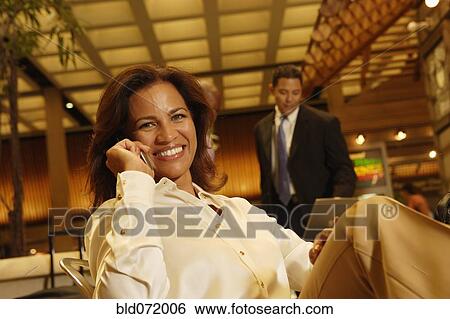 Stock Photograph - Hispanic businesswoman talking on cell phone. Fotosearch