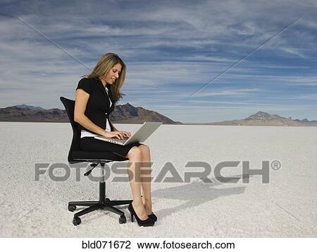 Stock Image - Hispanic businesswoman typing on laptop. Fotosearch