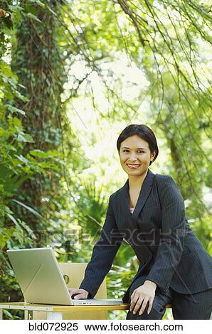 Hispanic businesswoman using laptop in woods View Large Photo Image Stock Photography - Hispanic businesswoman using laptop in woods. Fotosearch