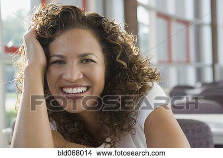 Picture - Hispanic businesswoman with head in hands. Fotosearch